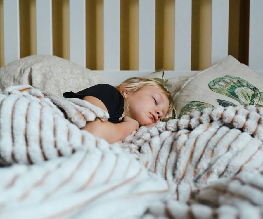 Schlafendes Kind unter einer gestreiften Decke