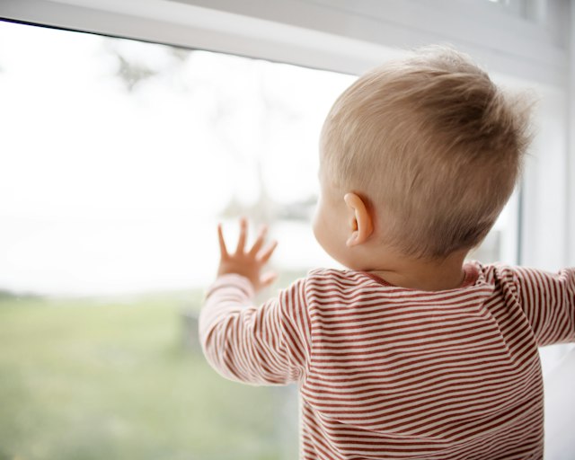 Kleinkind am Fenster im Morgenlicht
