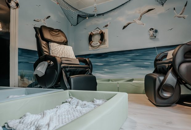 Blick in den Schlafraum mit Meereswandbild und Fischernetz unter der Decke